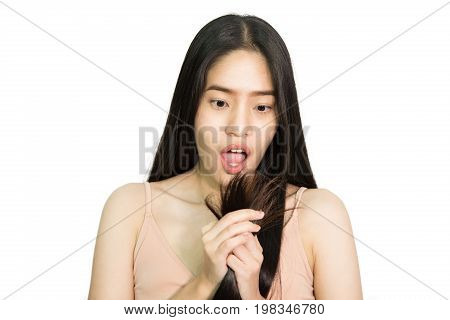 Beautiful young Asian woman shock and looking at her damaged hair , isolated on white background