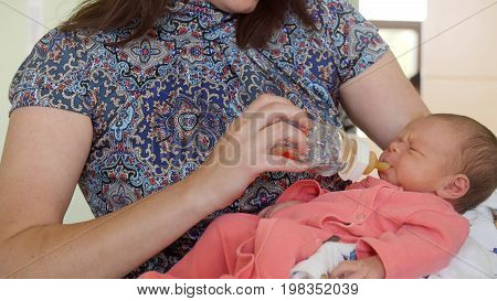 Newborn baby in maternity hospital - mother feeds her baby, close up
