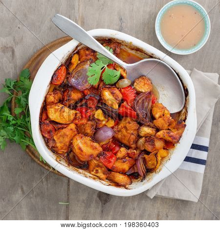 Baked chicken breast with vegetables on light rustic wooden background with copy space top view. Dinner table concept