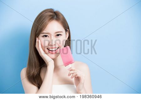 woman take popsicle and touch her face on the blue background