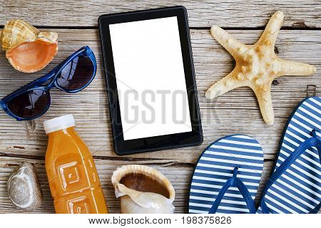 Beach background. Beach accessories, sea souvenirs and a tablet computer on a wooden background. Concept: beach vacation, vacation, travel, summer