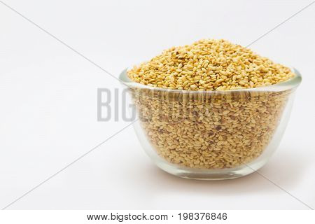 Glass bowl of seasame seeds on white background