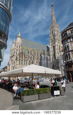 Vienna Austria - July 31 2017: Stephansplatz in Central Vienna with famous St. Stephens Cathedral. Tourists are walking around or relax in a restaurant on a sunny day