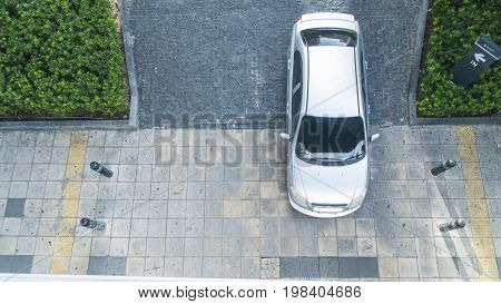 the top aerial view of people walk on the city pedestrian walkway of the entrance to street building with the landscape of green space of trees and shrub.