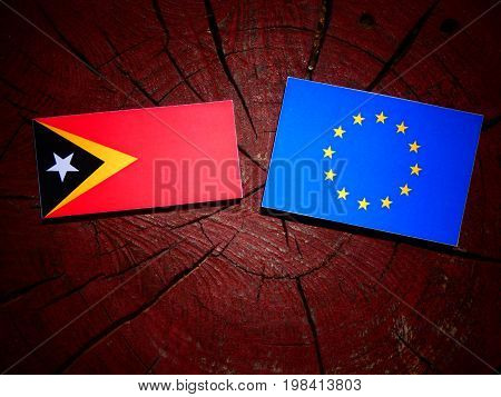 East Timorese Flag With Eu Flag On A Tree Stump Isolated