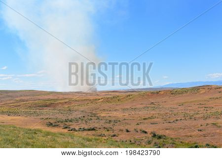 Prairie Fire in Wyoming. Smoke rises from a small brush fire.