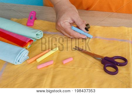 closeup of woman hands sewing yellow cloth outdoors. Woman's Hand Sewing Quilt