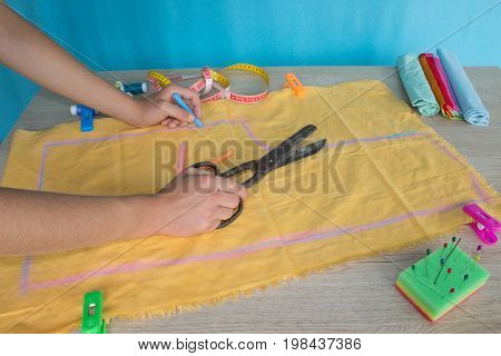 closeup of woman hands sewing yellow cloth outdoors. Woman's Hand Sewing Quilt