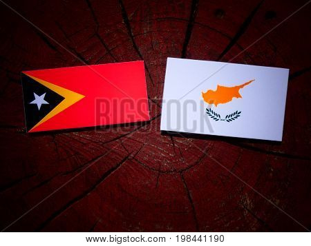 East Timorese Flag With Cypriot Flag On A Tree Stump Isolated
