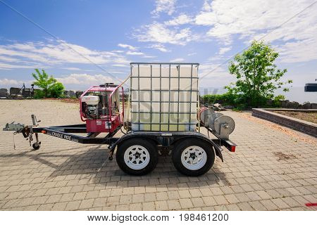 Toronto, Ontario, Canada, June 16, 2017, nice closeup view of a small trailer with plastic box in metal frame and engine mounted on trailer frame, Ontario place construction site, landscaping