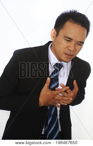Photo image of a handsome attractive young Asian Businessman holding his heart in pain isolated on white