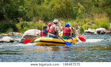 Rafting along the rough river rapids. Extreme vacation in nature.