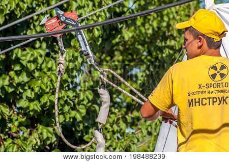 Ukraine Migea - July 30 2017: Zipline. The instructor prepares equipment for the ziplining. Starting platform on a high rock. Extreme and active rest.