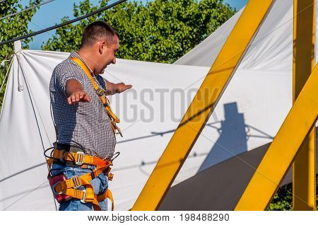 Ukraine Migea - June 30 2017: Zipline. A person checks the equipment before zipling. Starting platform on a high rock. Extreme and active rest.