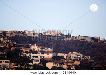 Moon rising over cliffside luxury homes