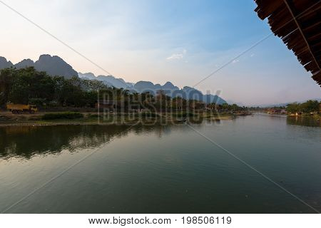 Panorama picture of Nam Song River with tropical vegetation and mountains at Vang Vieng Laos.