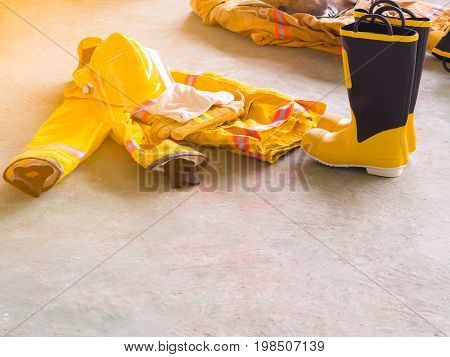 Yellow Fireproof Uniform Of Firefighters. On The Floor. Flare Light.