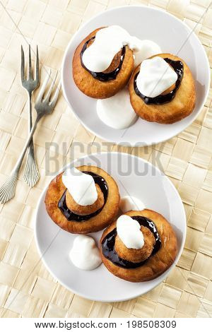 Sweet dessert of beignets with chocolate and cream