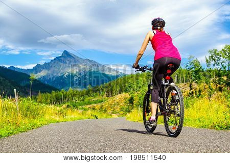 Woman on MTB bike on road in Ticha valley at High Tatras mountains Slovakia.