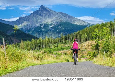 Woman on MTB bike on road in Ticha valley at High Tatras mountains Slovakia.