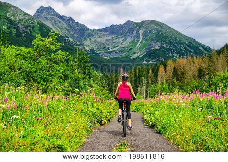 Woman on MTB bike on road in Ticha valley at High Tatras mountains Slovakia.