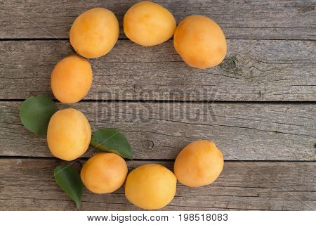 Letter C made from apricots on a wooden background. Vitamin C concept.