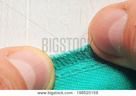 Inner seam on clothes pressed close to the table with hands. Close-up shot of a tailor at work