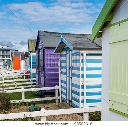 Colorful painted beach hut on its own plot of land along the coast of Devon in Southern England