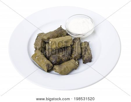 Stuffed grape leaves with sour cream.   Isolated on a white background.