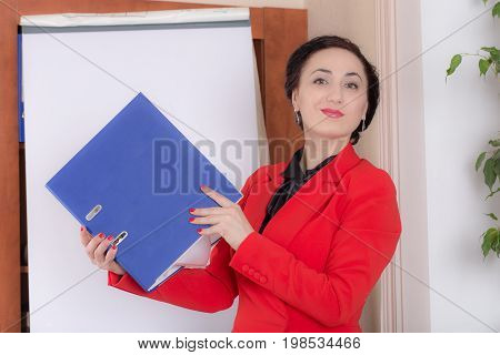 Business woman holdind the thick blue folder. Photo can be used as a whole background.