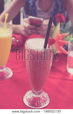 Iced watermelon juice glass on a red table in restaurant and cafe interior. Tropical island of Bali.