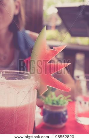 Iced watermelon juice glass on a red table in restaurant and cafe interior. Tropical island of Bali.