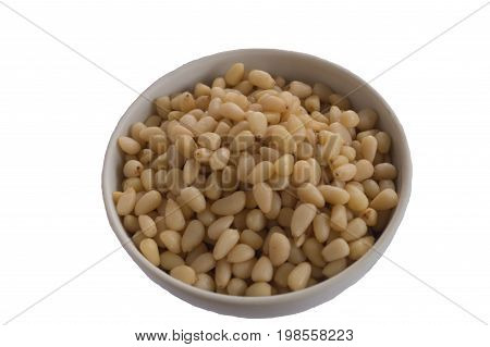 Pine nuts in the white ceramic small bowll isolated on white background