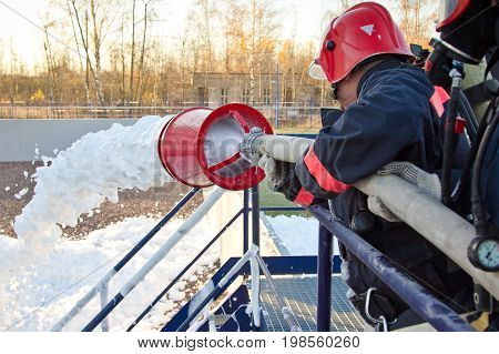 Training of firemen. The fireman extinguishes the fire with foam