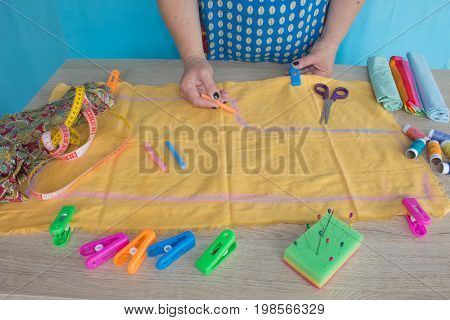 closeup of woman hands sewing yellow cloth outdoors. Woman's Hand Sewing Quilt