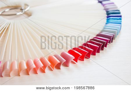 Samples of colored nail polish on a white table. Nail salon.