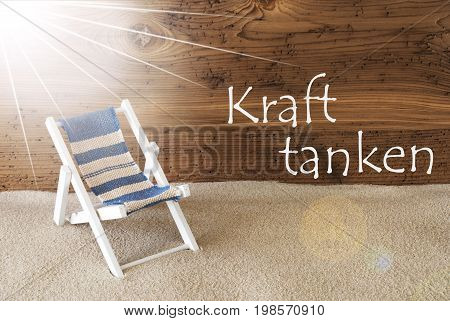 Sunny Summer Greeting Card With Sand And Aged Wooden Background. German Text Kraft Tanken Means Relax. Deck Chair For Holiday Or Vacation Feeling.