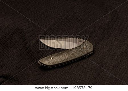 Black Knife In A Curved Shape On A Black Background.