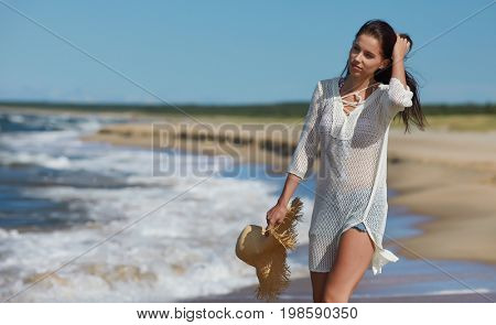 Young woman walking on white sand to beautiful beach, Baltic Sea, Poland