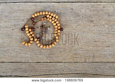 Rosary beads on the old wooden table
