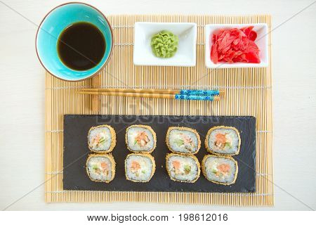 Sushi Rolls On Black Slate Surface. Japanese Food. Hot Fried Sushi Roll