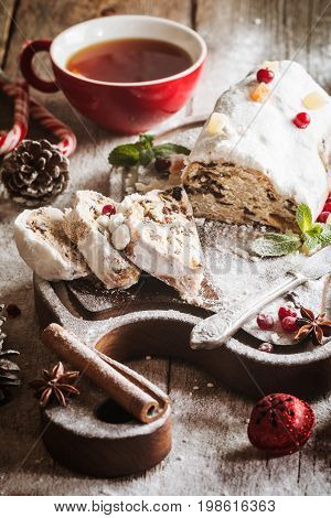 Christmas stollen, traditional German, European festive dessert cut into pieces on wooden background.