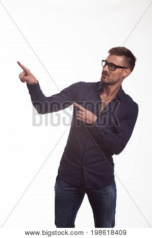 Young jocular man portrait of a confident businessman showing by hands on a gray background. Ideal for banners, registration forms, presentation, landings, presenting concept.