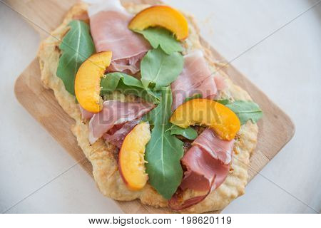 Home made tarte flambee with ham and arugula