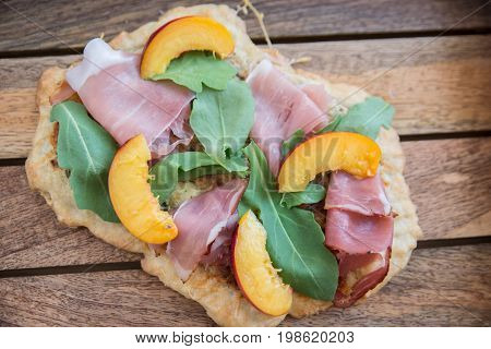 Home made tarte flambee with ham and arugula