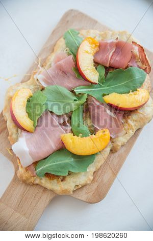 Home made tarte flambee with ham and arugula