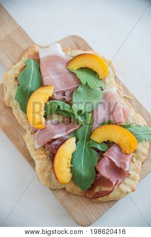 Home made tarte flambee with ham and arugula