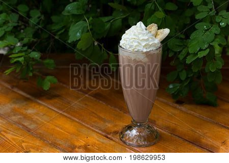 banana smoothie in a glass On a wooden background. banana cocktail. copy space.
