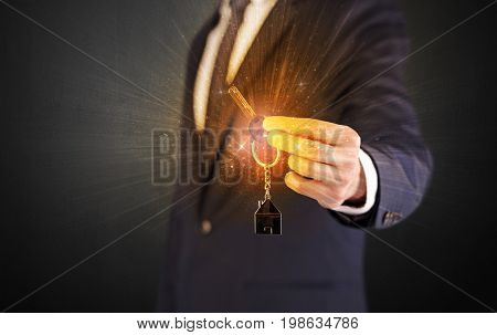 Formal man hand over shiny keys with dark background