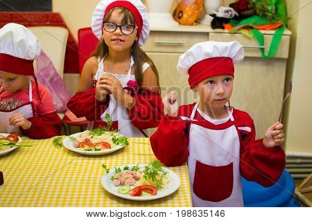 Alchevsk, Ukraine - July 30, 2017: School Cooks For Children. Learn To Cook Pasta With Sausages